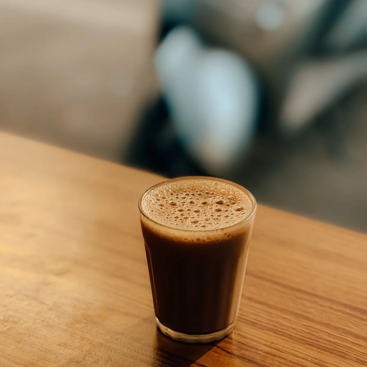 A glass of chai on a wooden table
